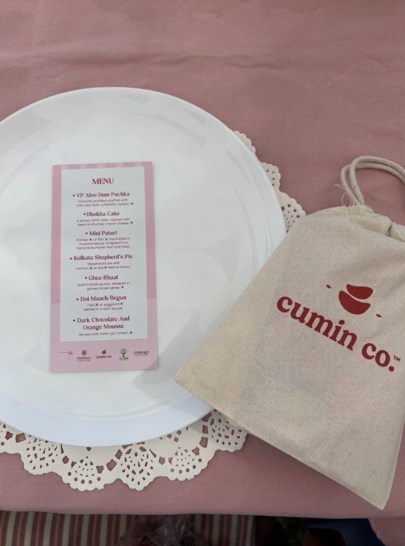 Menu card and Cumin Co. tote on the pink table