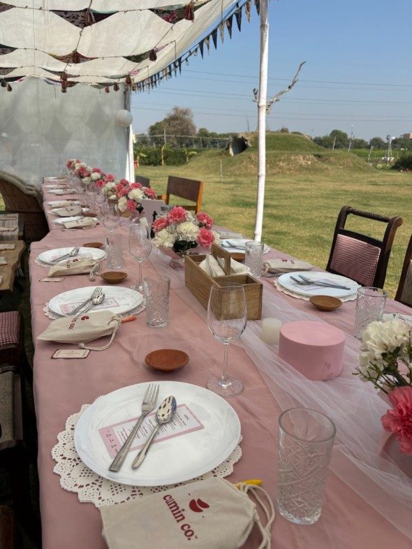 The long pink communal table set under bunting at The Farm Collective
